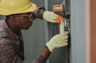 Elektriker montiert eine Unterputzdose an einer Wand
