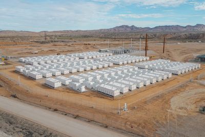 Reihen weißer Batteriecontainer eines großen Speichers auf einem eingezäunten Gelände
