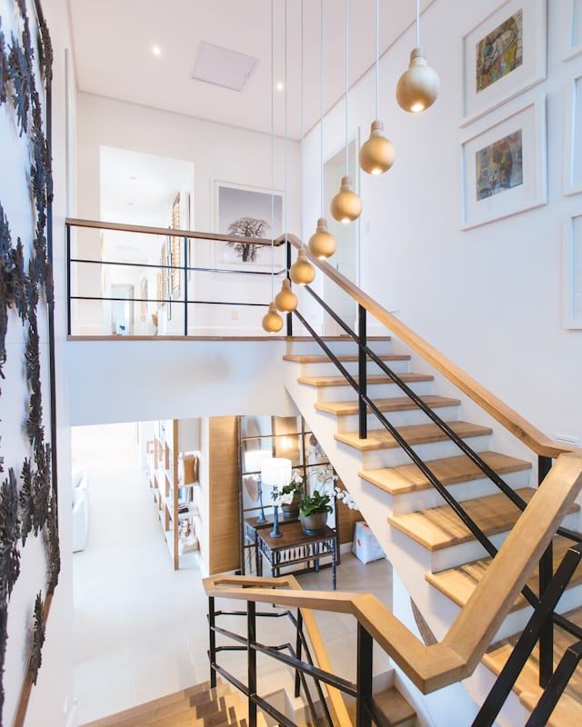 Helles Treppenhaus mit Pendelleuchten in einem Altbau