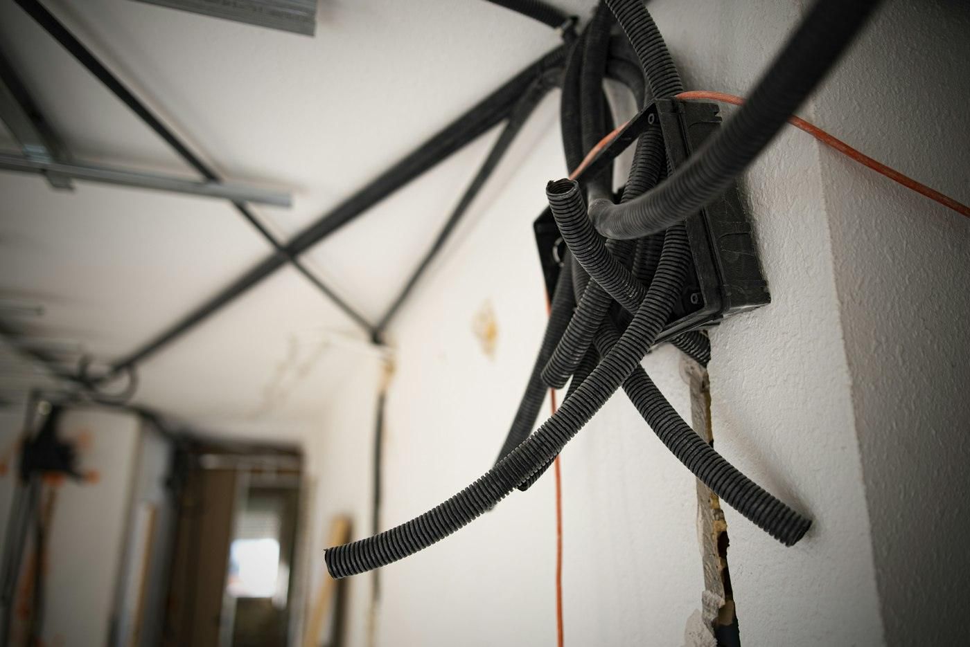 Offene Wand während einer Sanierung mit Leerrohren und Leitungen